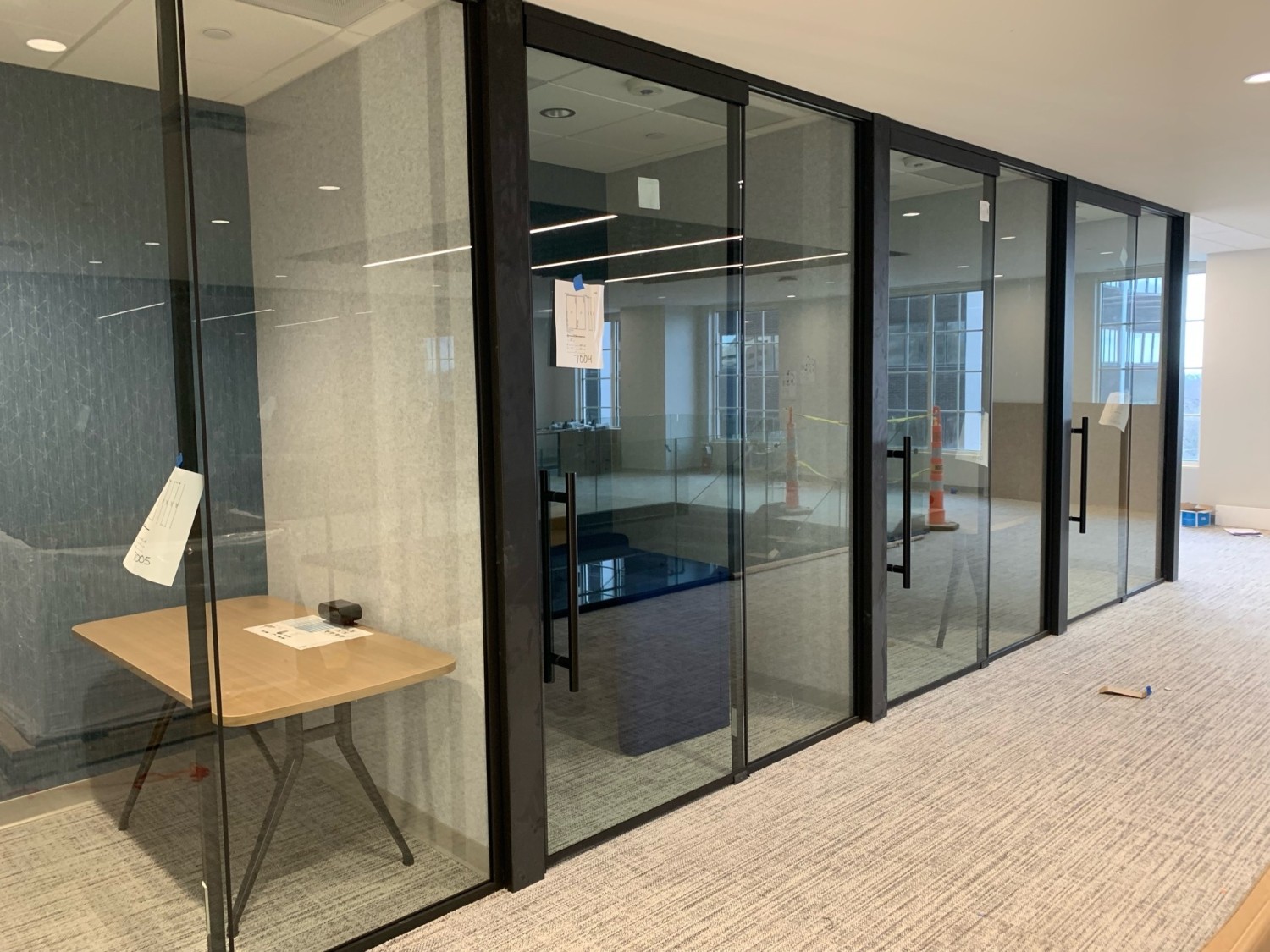 Glass-front architectural wall installation in a modern commercial office