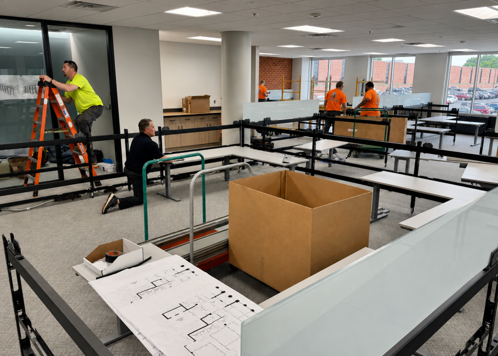 Commercial furniture installation crew assembling office workstations during a corporate office project.